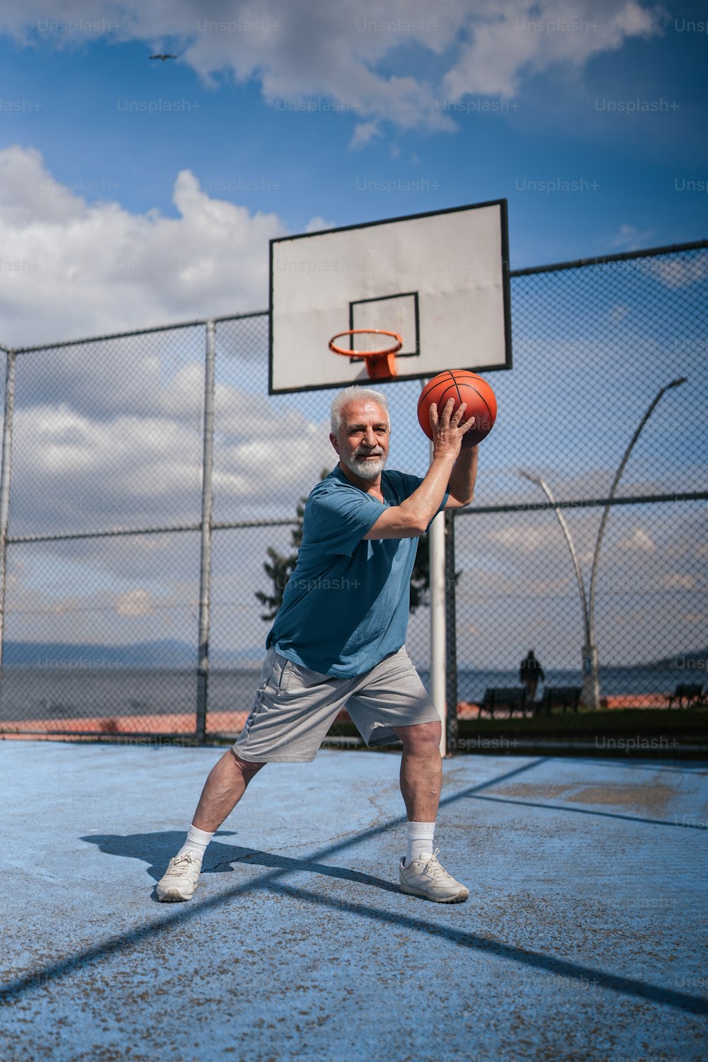 Un uomo che tiene un pallone da basket su un campo da basket