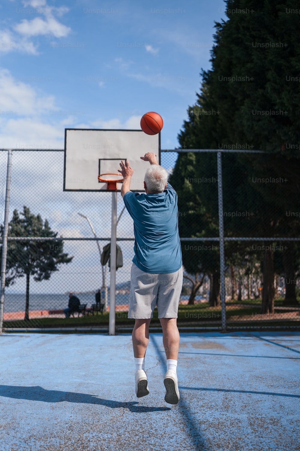 an older man is playing basketball on a court