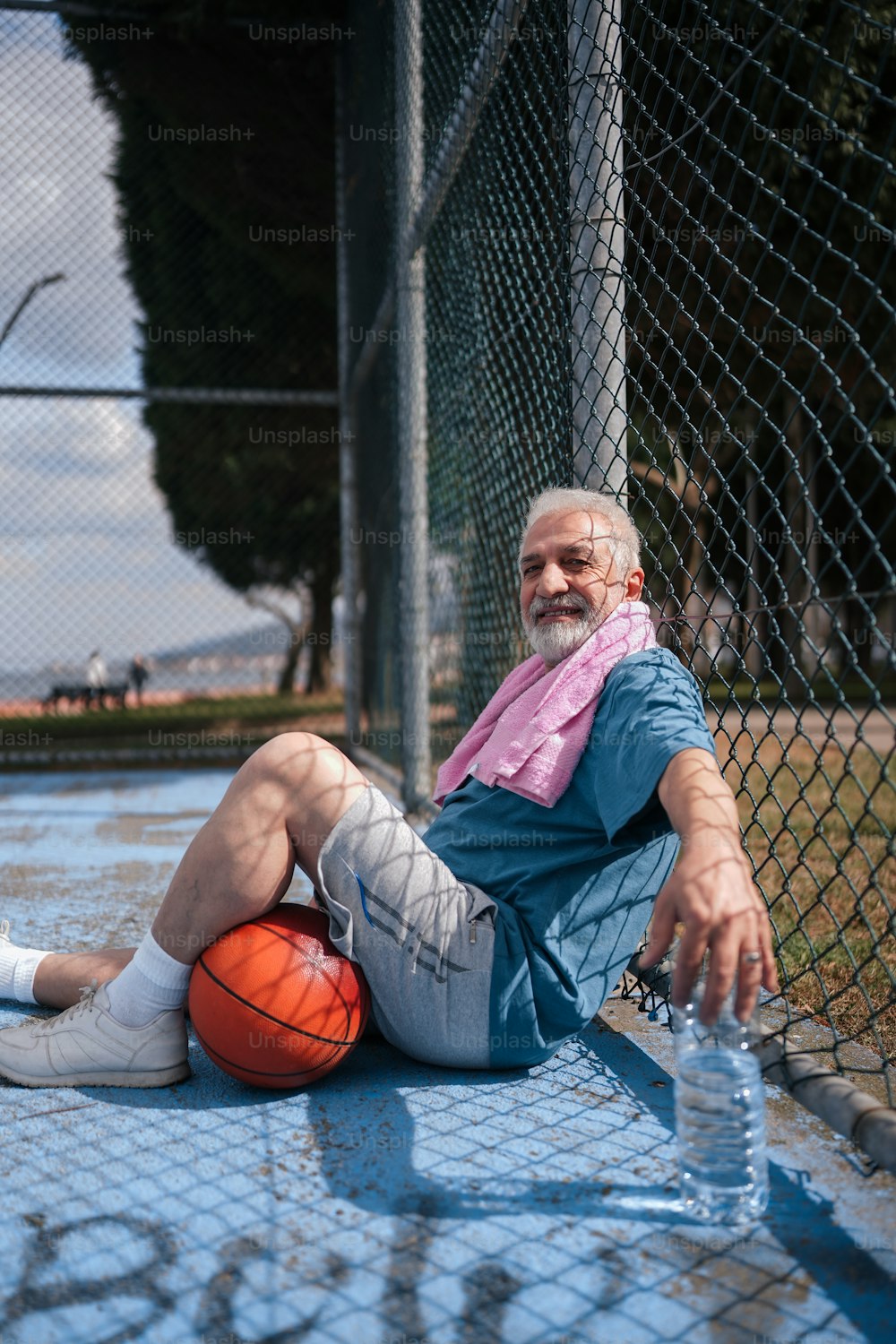 バスケットボールを持って地面に座って�いる男