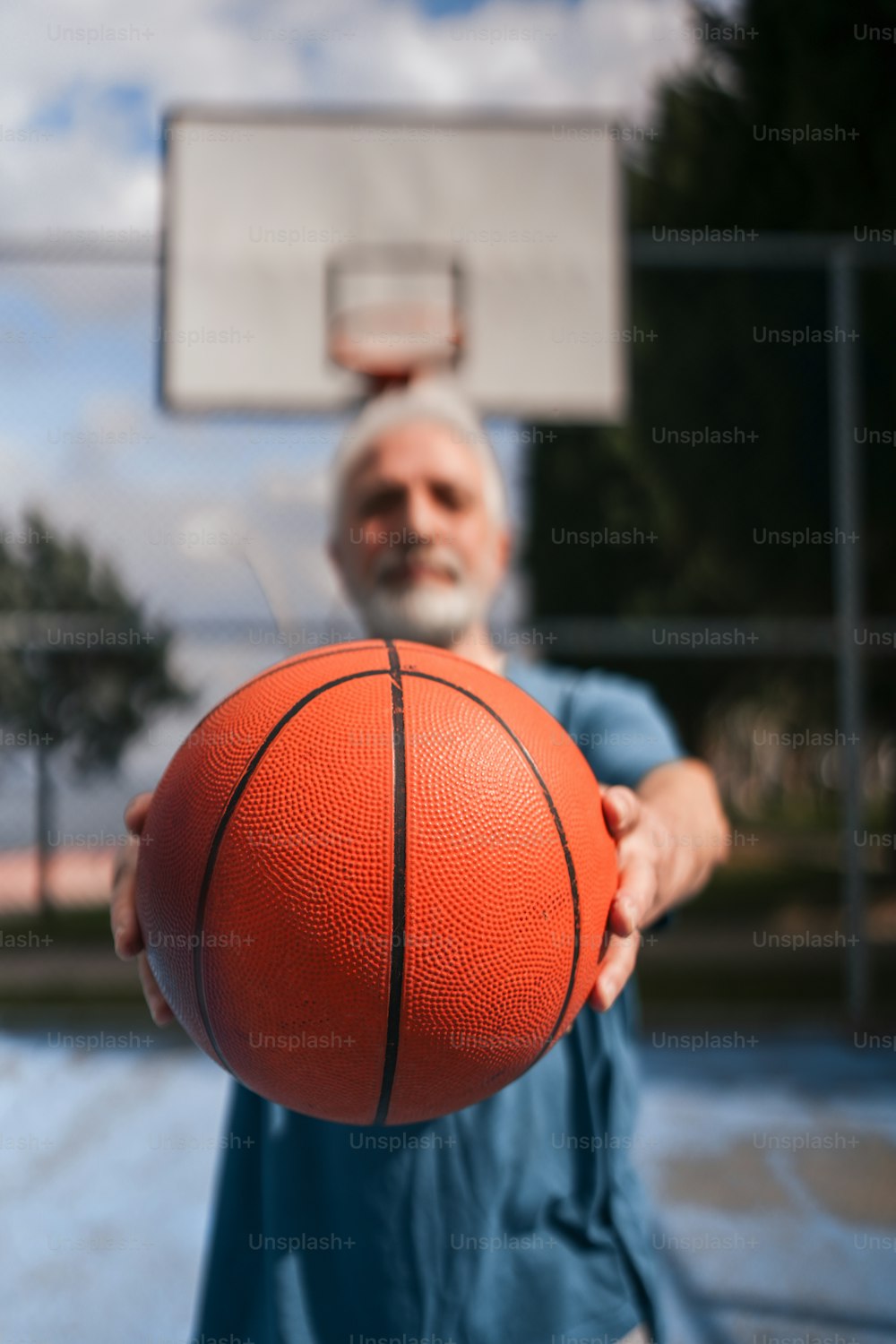 バスケットボールのフープの前でバスケットボールを持っている男性