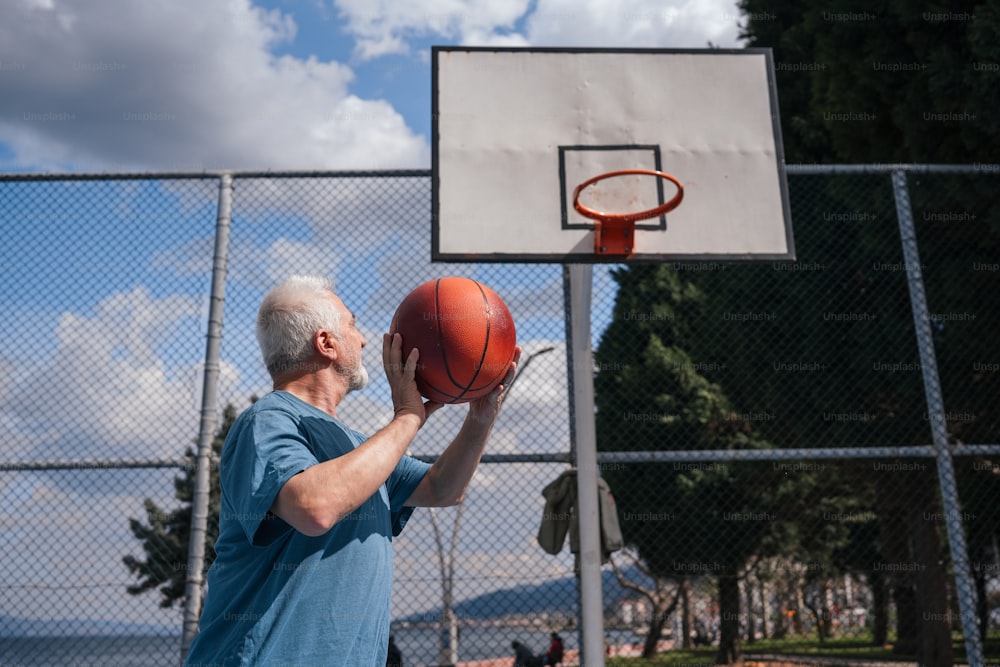 a man holding a basketball in front of a basketball hoop