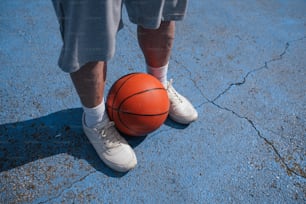 a person standing next to a basketball on the ground