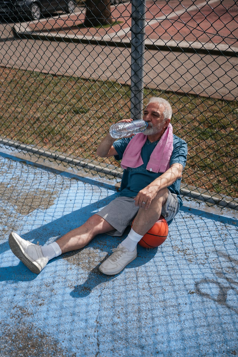 Un hombre sentado en el suelo con una raqueta de tenis en la mano