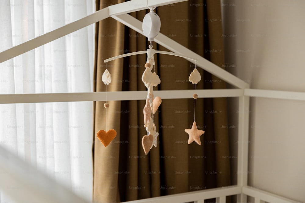 a baby crib with a mobile hanging from it's side
