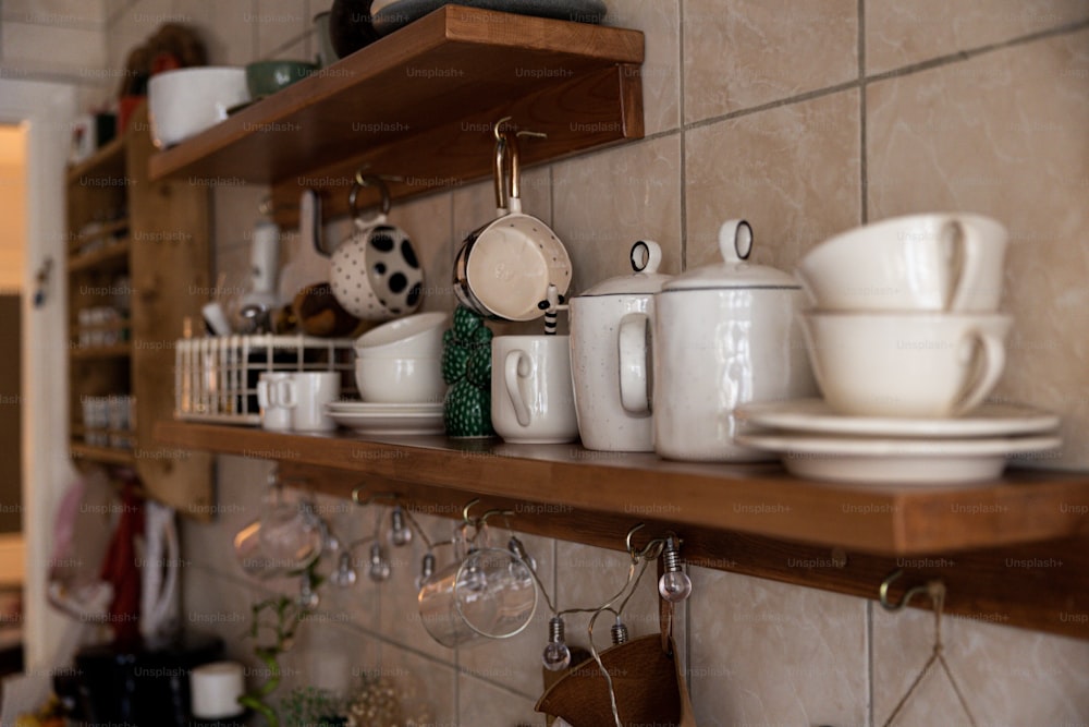 Un estante de cocina lleno de platos blancos y tazas