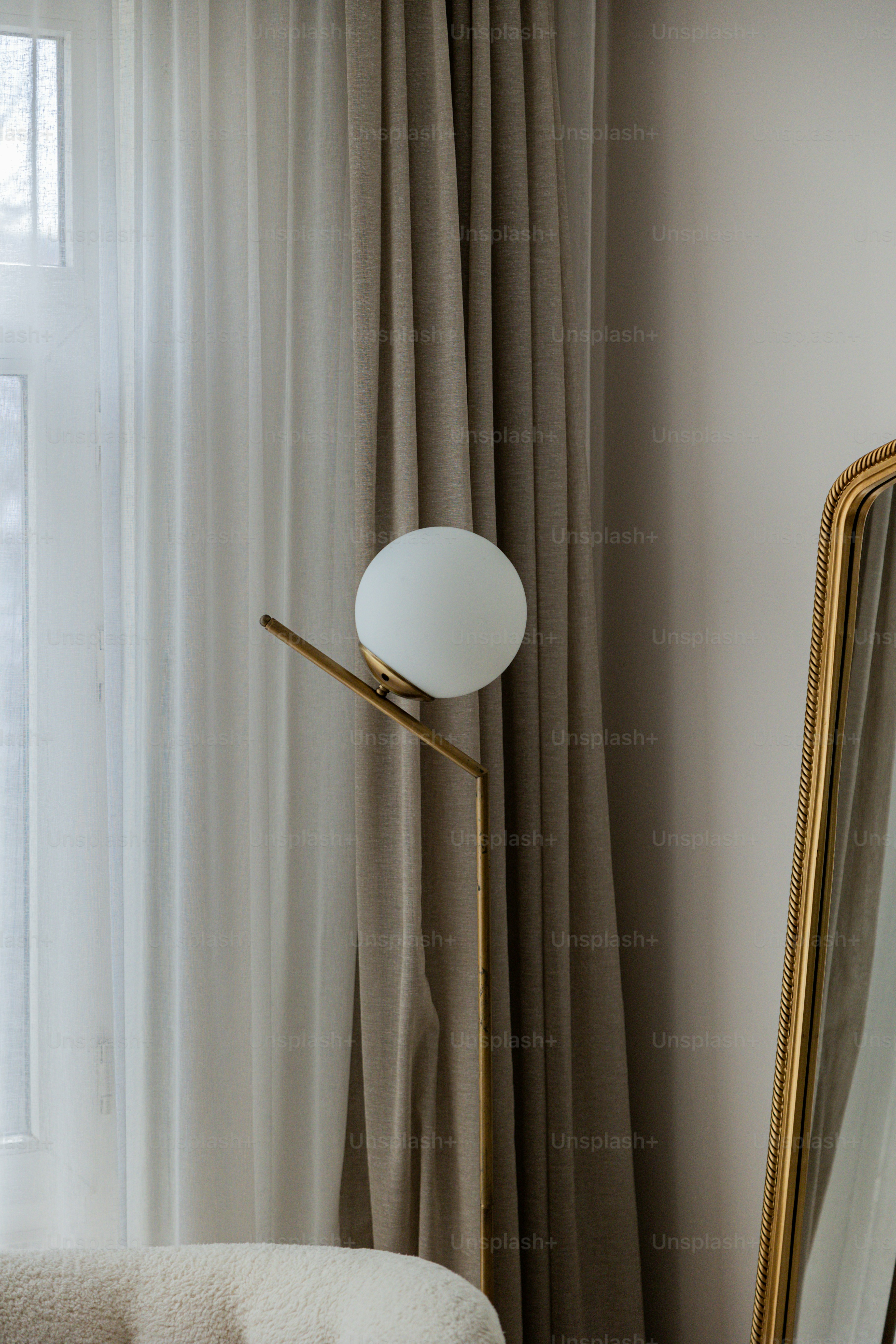 a room with a chair, a lamp and a mirror