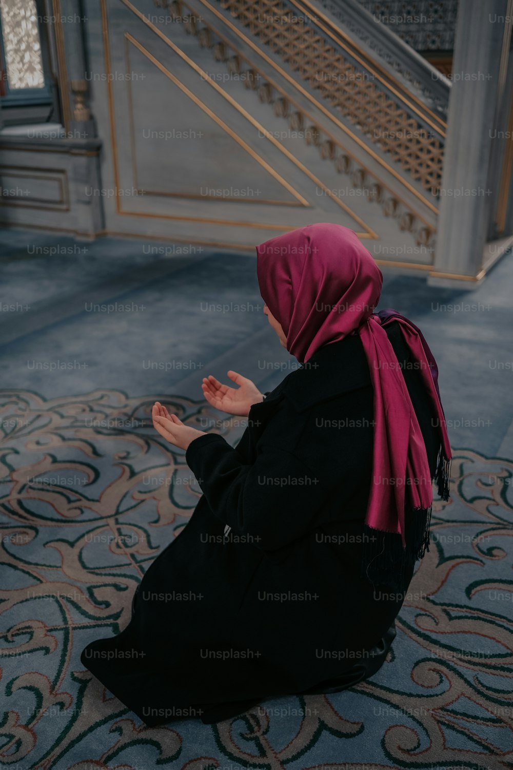 Una mujer sentada en el suelo rezando
