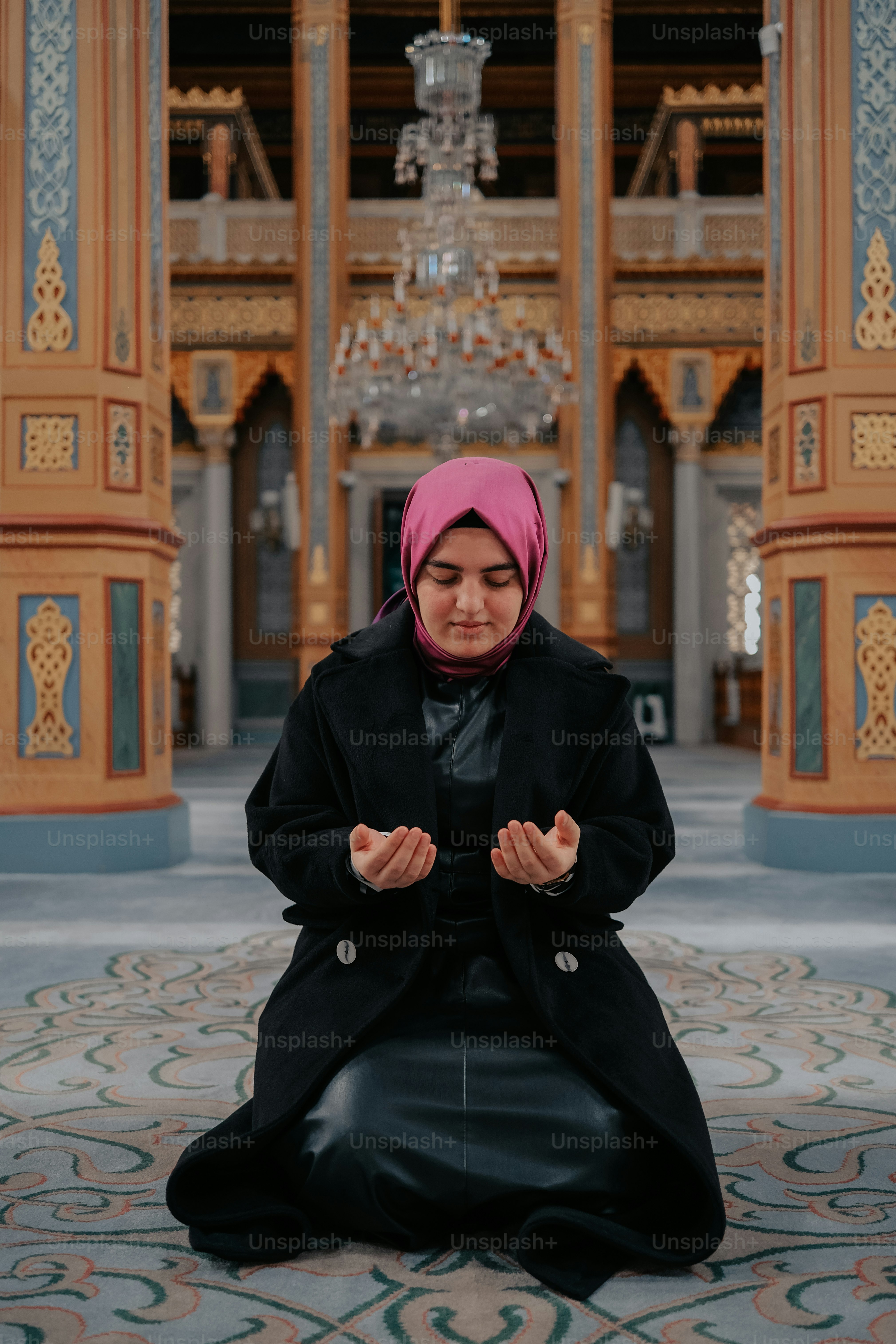 Una mujer con un vestido negro y un pañuelo rosa en la cabeza