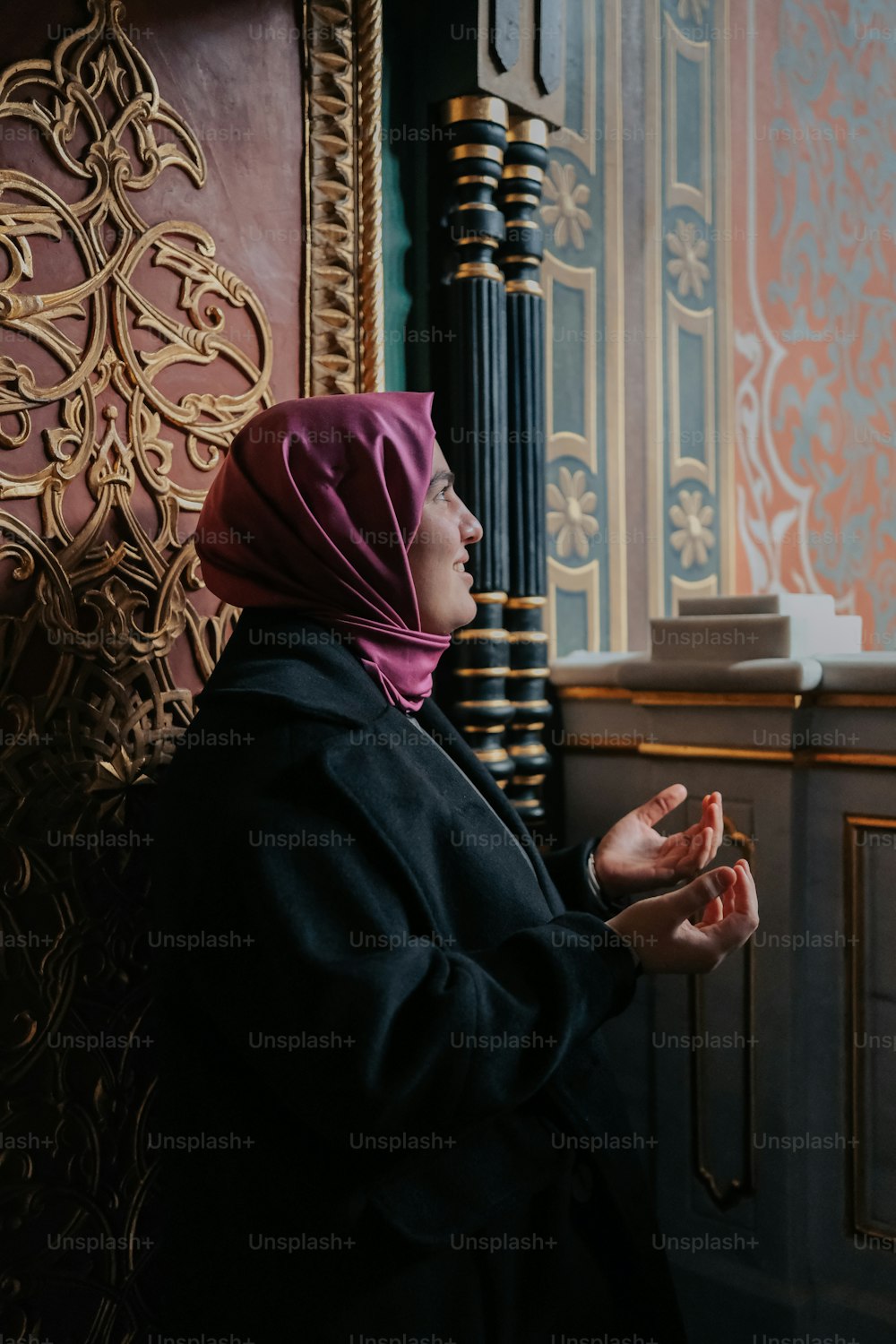 uma mulher em um hijab em pé na frente de uma parede