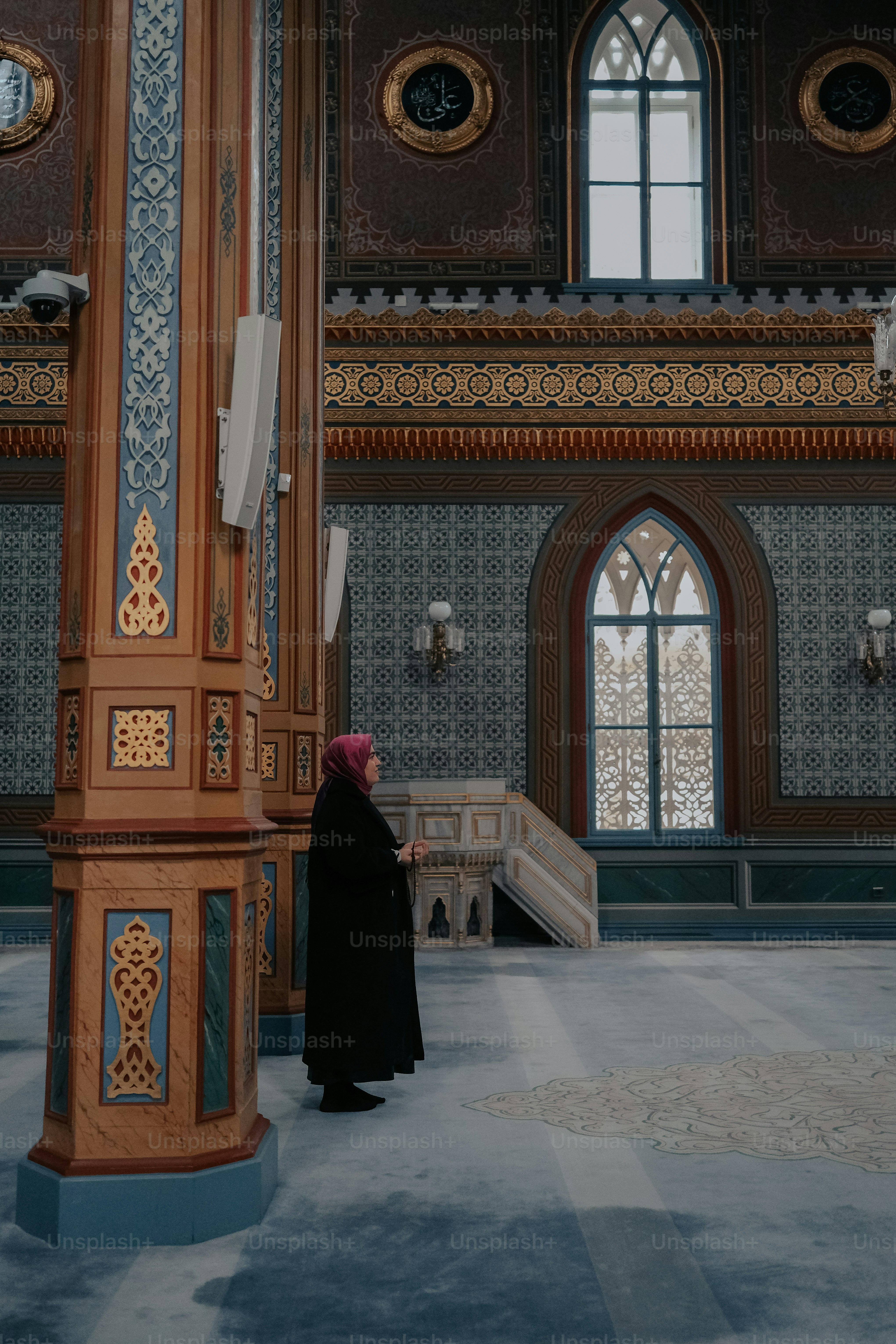 Una mujer parada en una habitación grande con un reloj en la pared