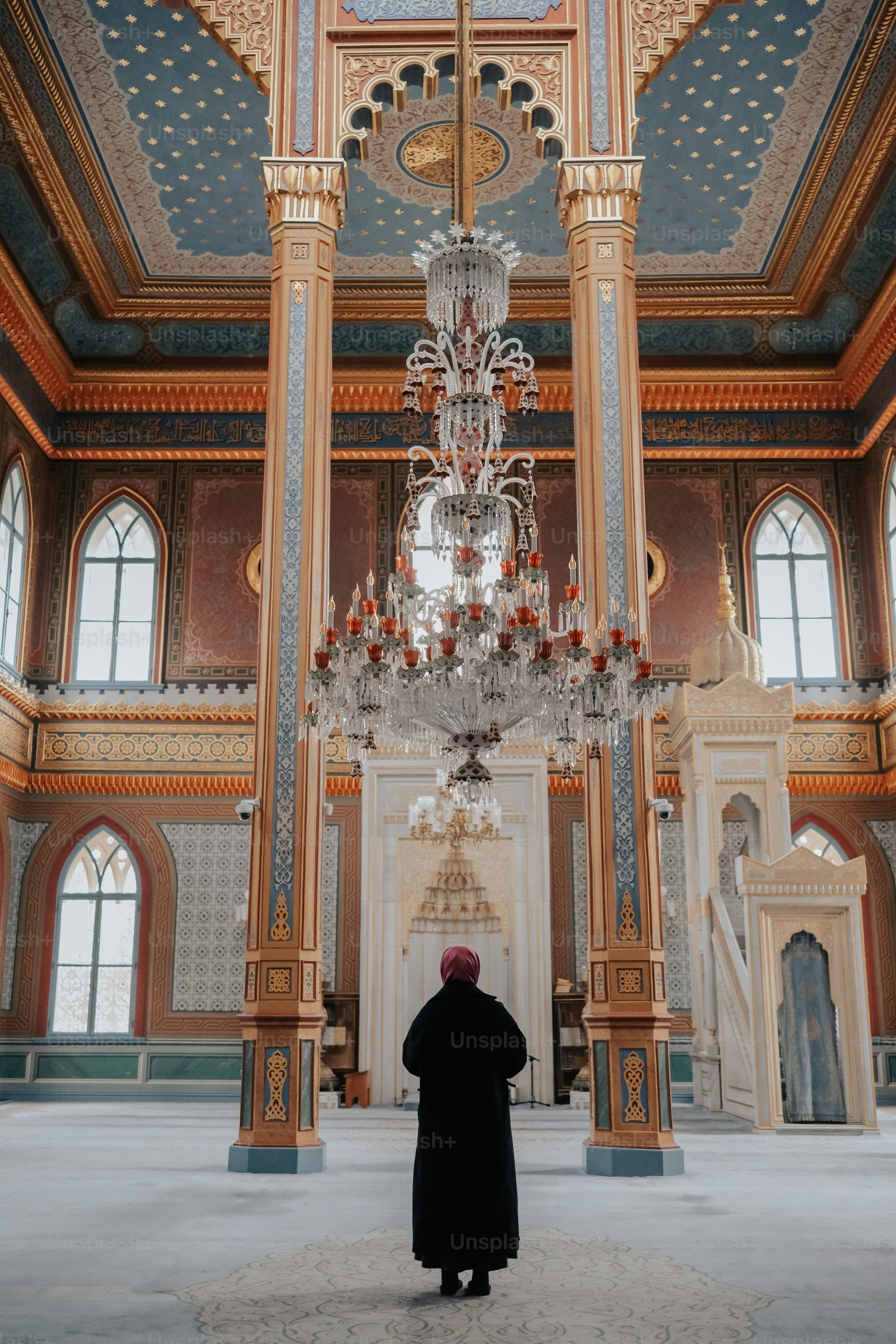 Eine Person, die in einem großen Raum mit einem Kronleuchter steht