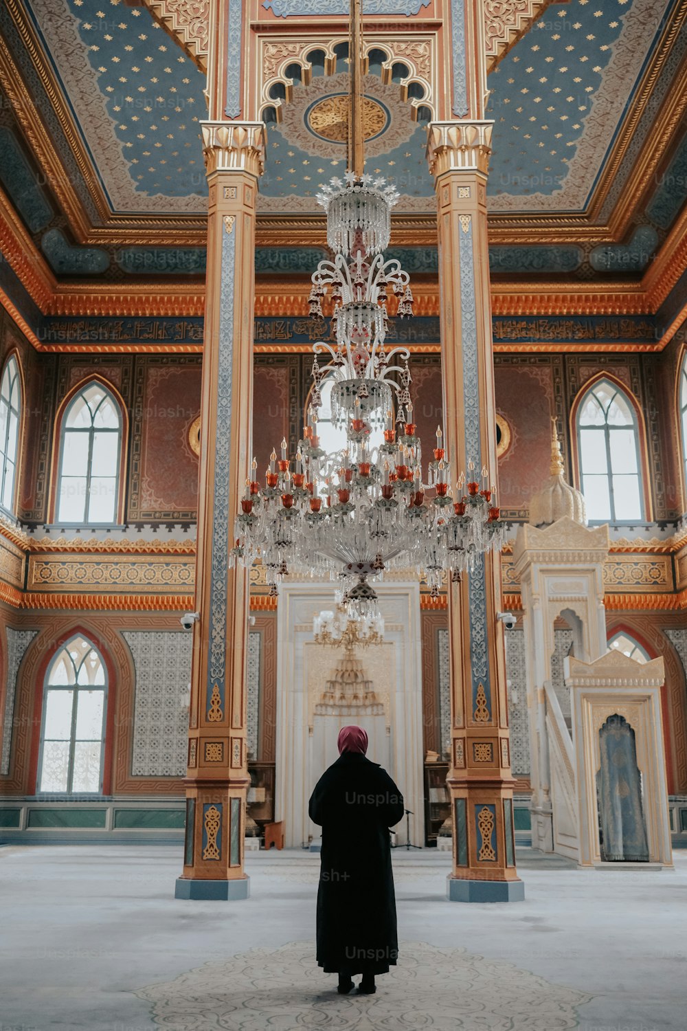 a person standing in a large room with a chandelier