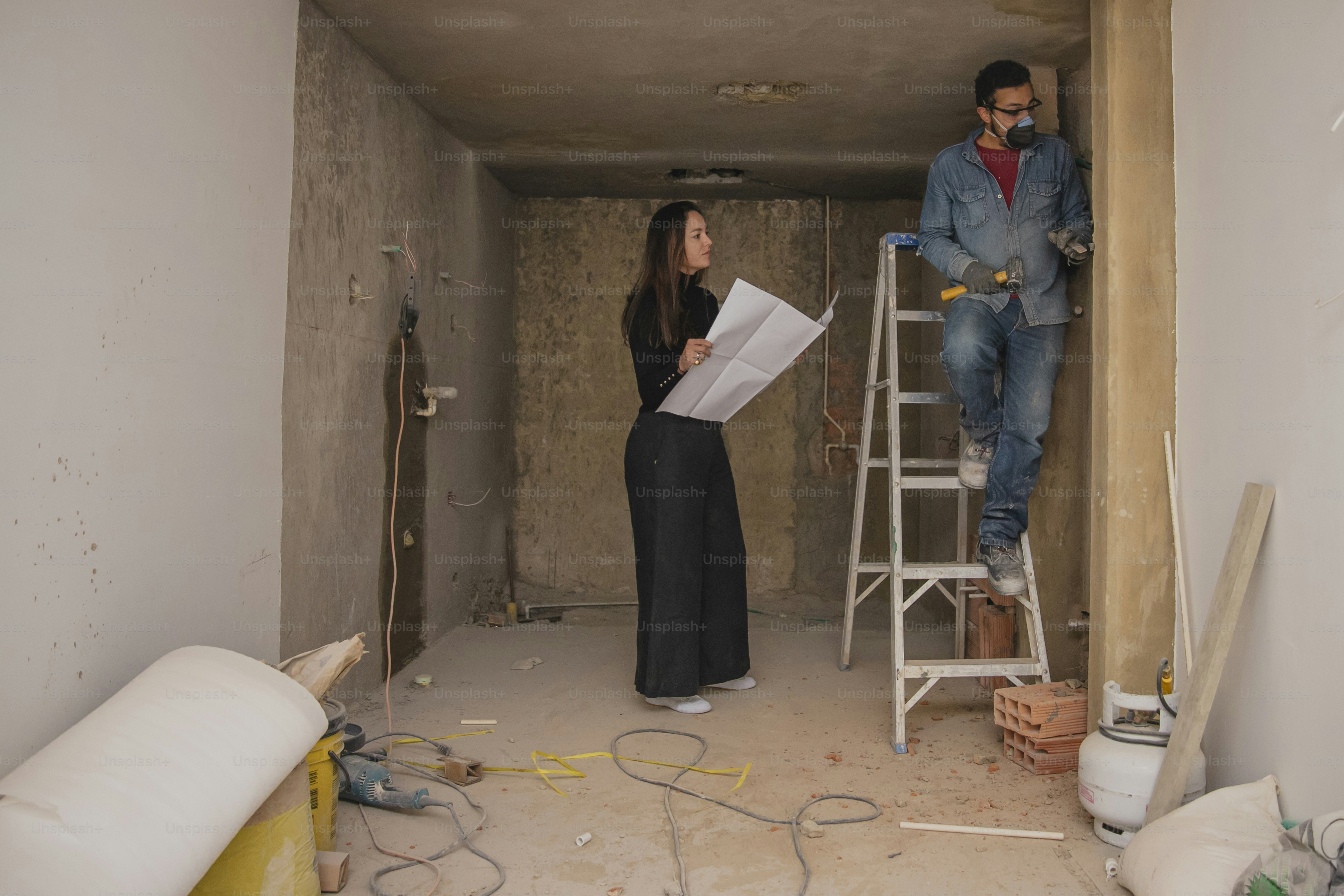 a man and a woman standing in a room under construction