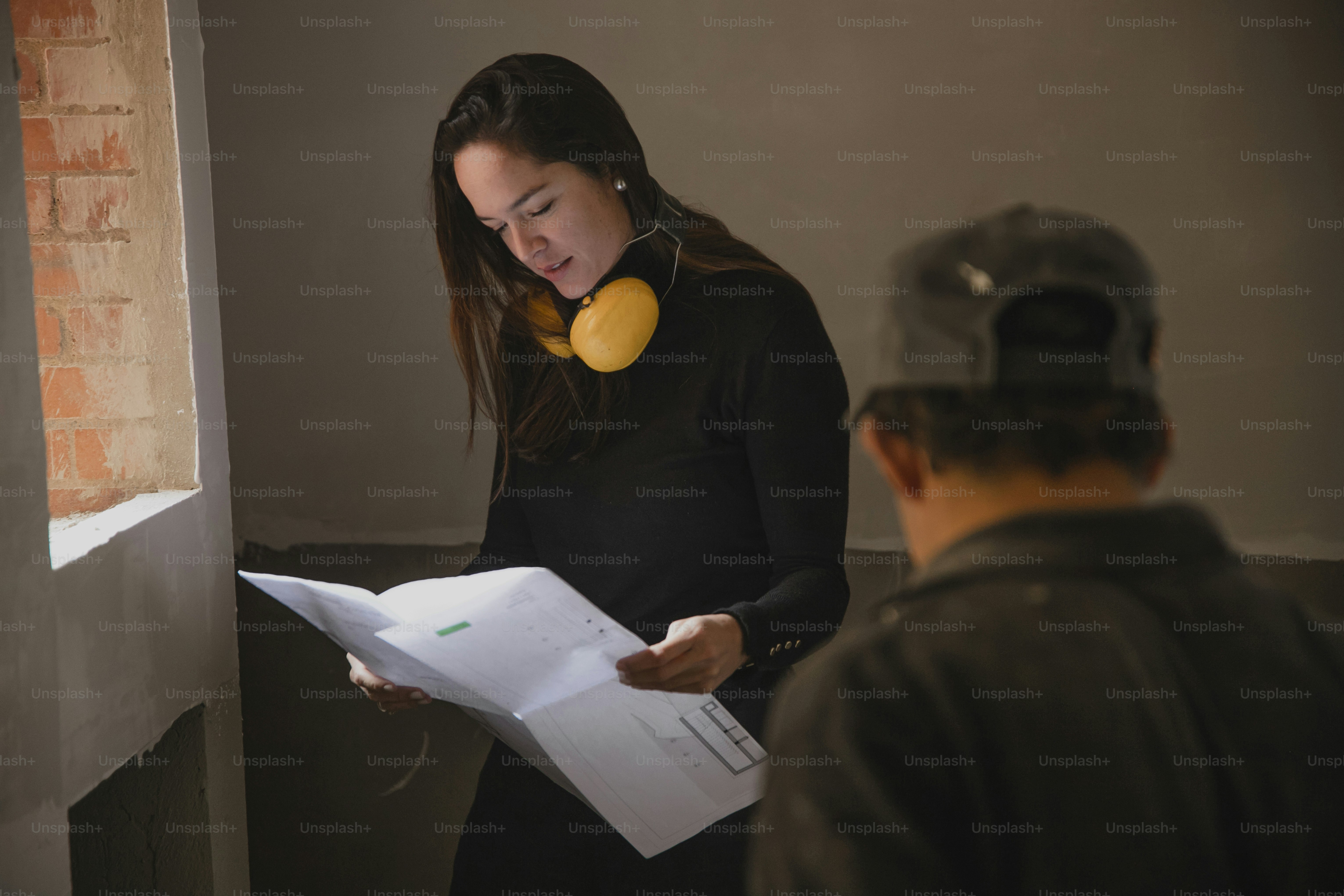 a woman holding a piece of paper while standing next to a man