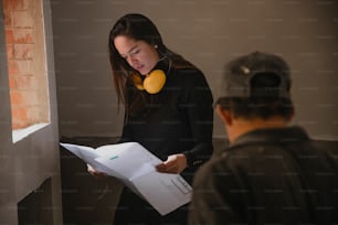 Una mujer sosteniendo un pedazo de papel mientras está de pie junto a un hombre