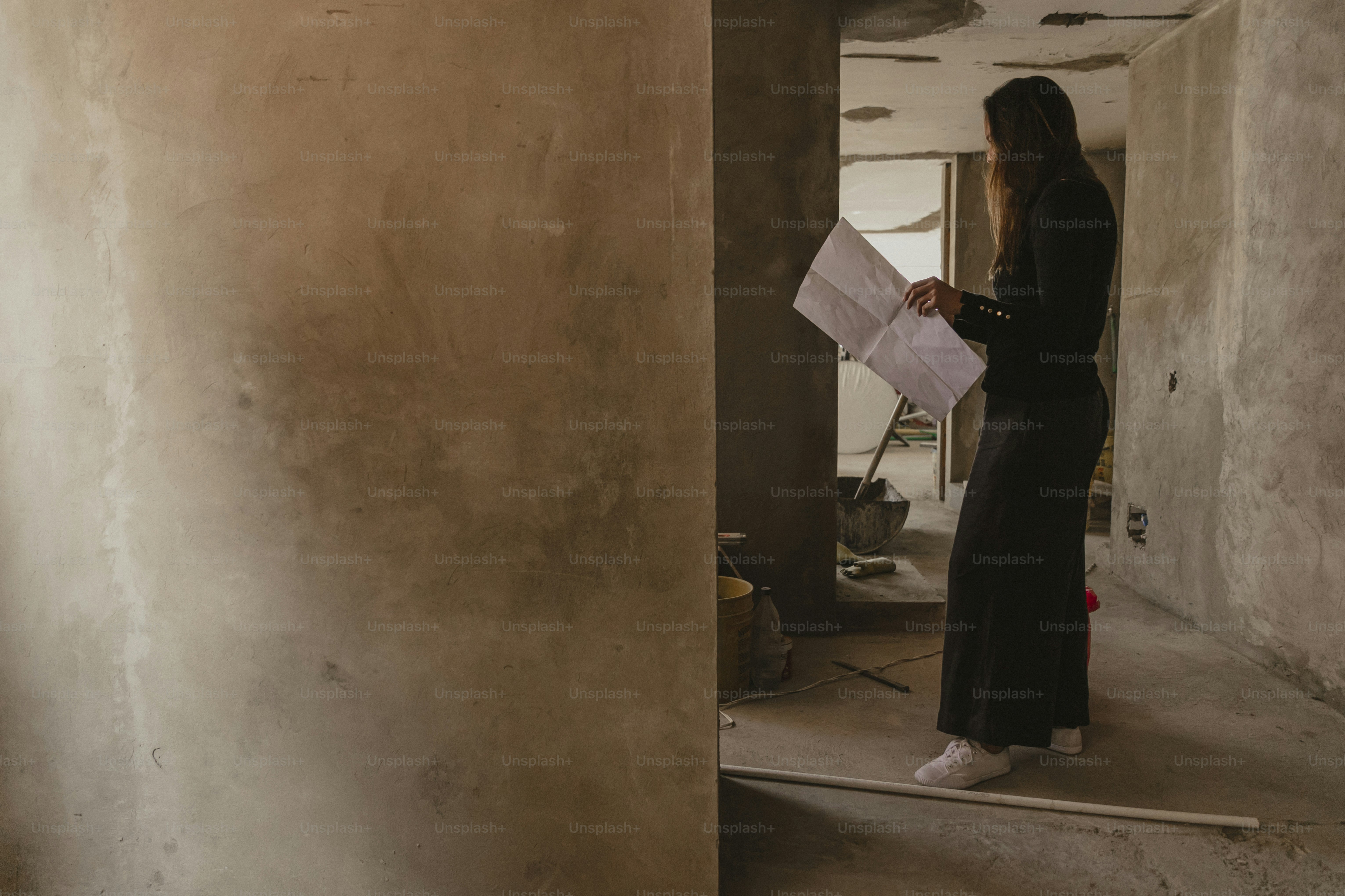 a woman standing in a room holding a piece of paper