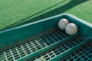 two golf balls sitting in a green container