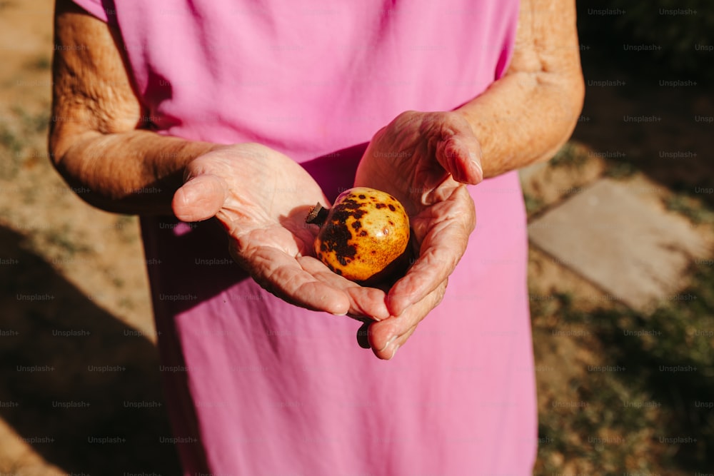 Una donna in un vestito rosa che tiene un muffin tra le mani