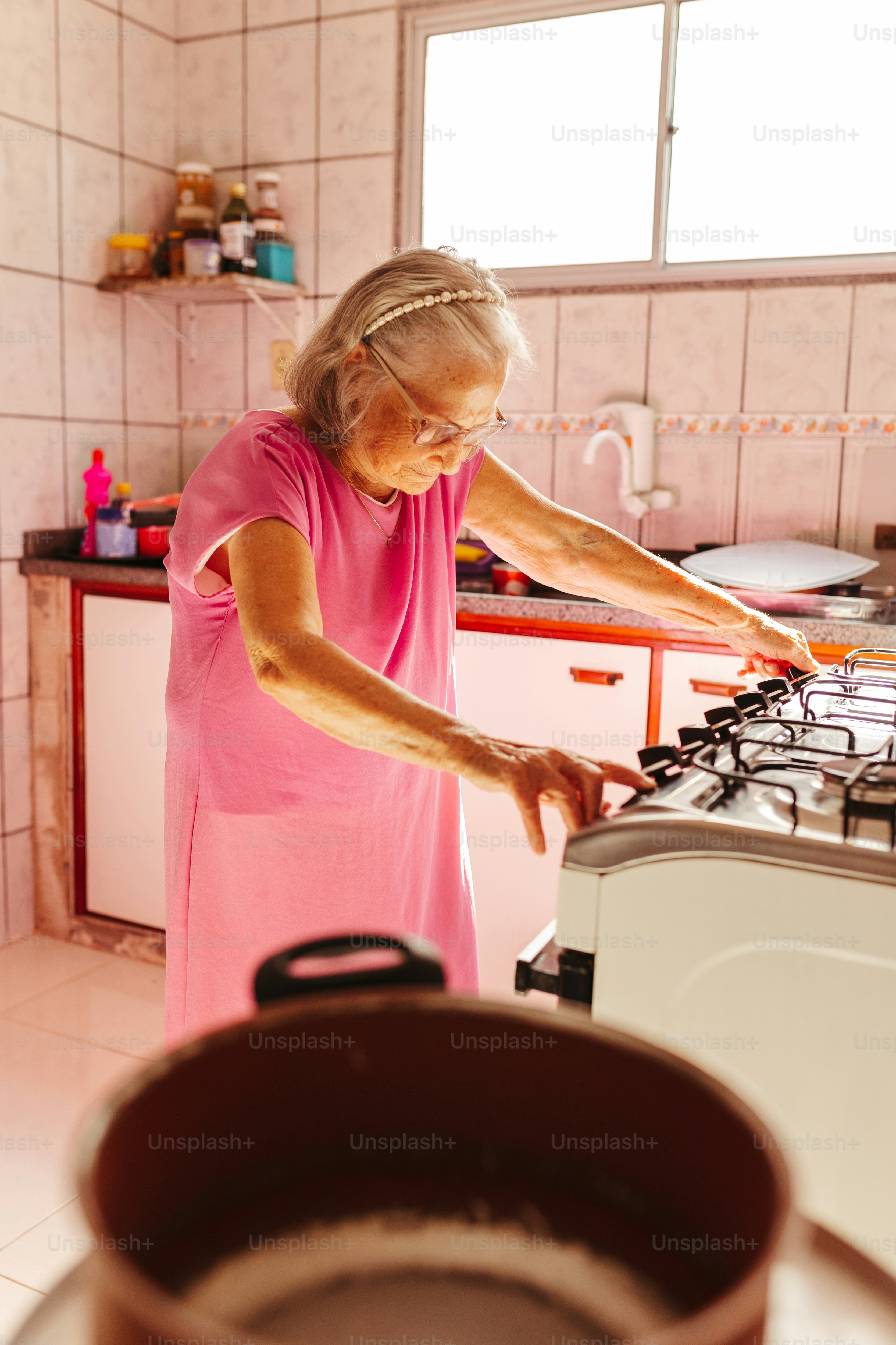 Una mujer con un vestido rosa parada en una cocina
