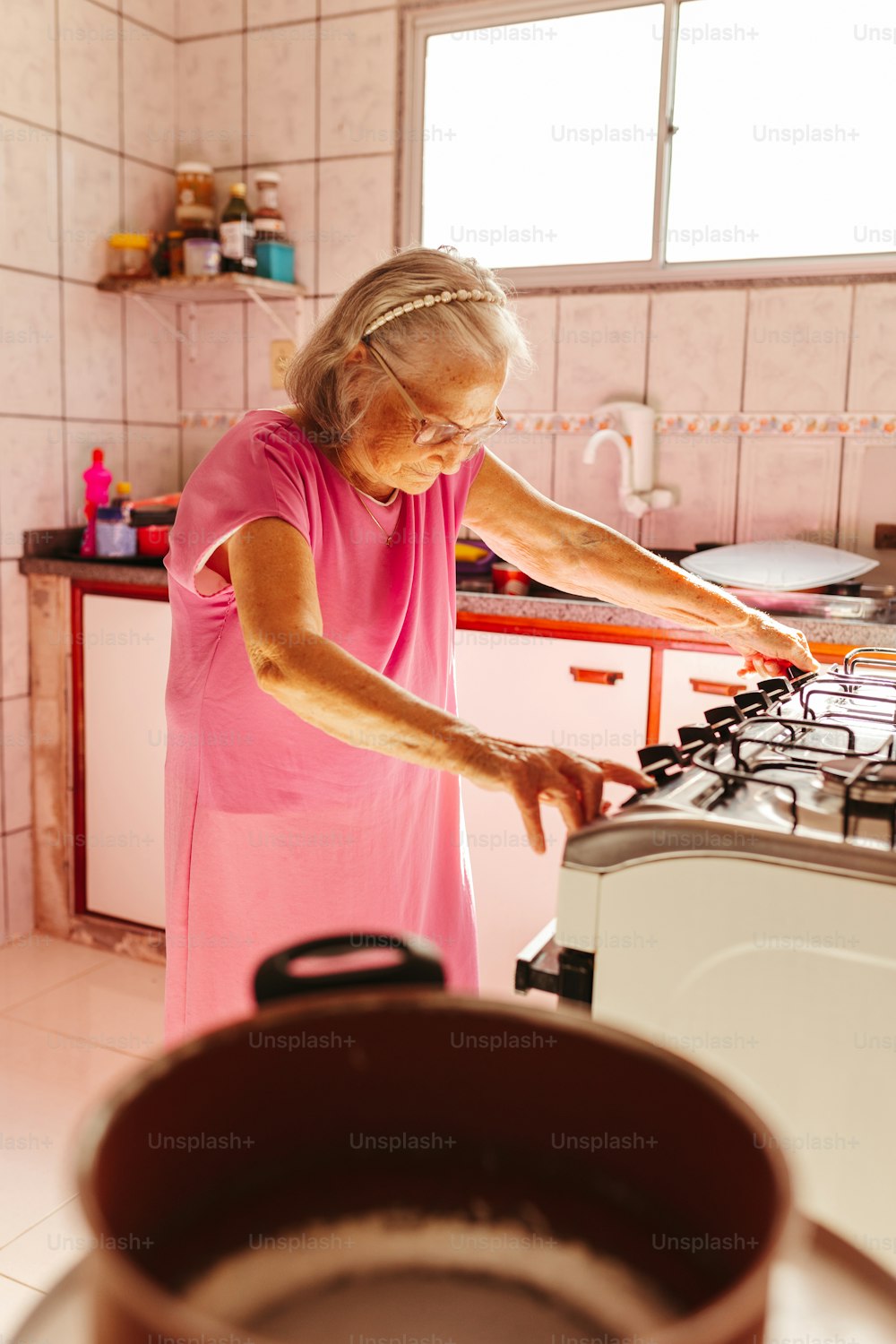 a woman in a pink dress standing in a kitchen
