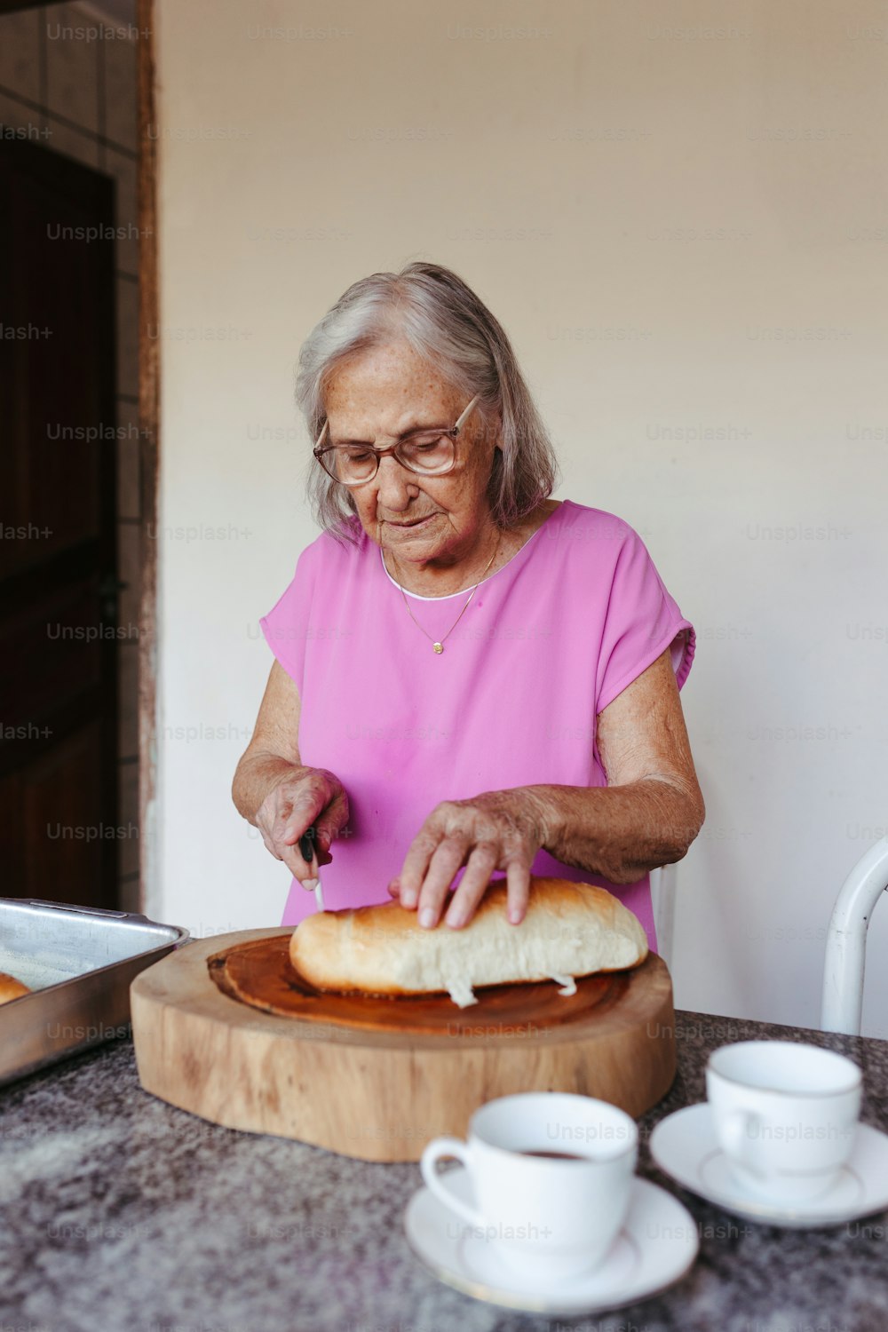 a woman in a pink shirt is making a sandwich