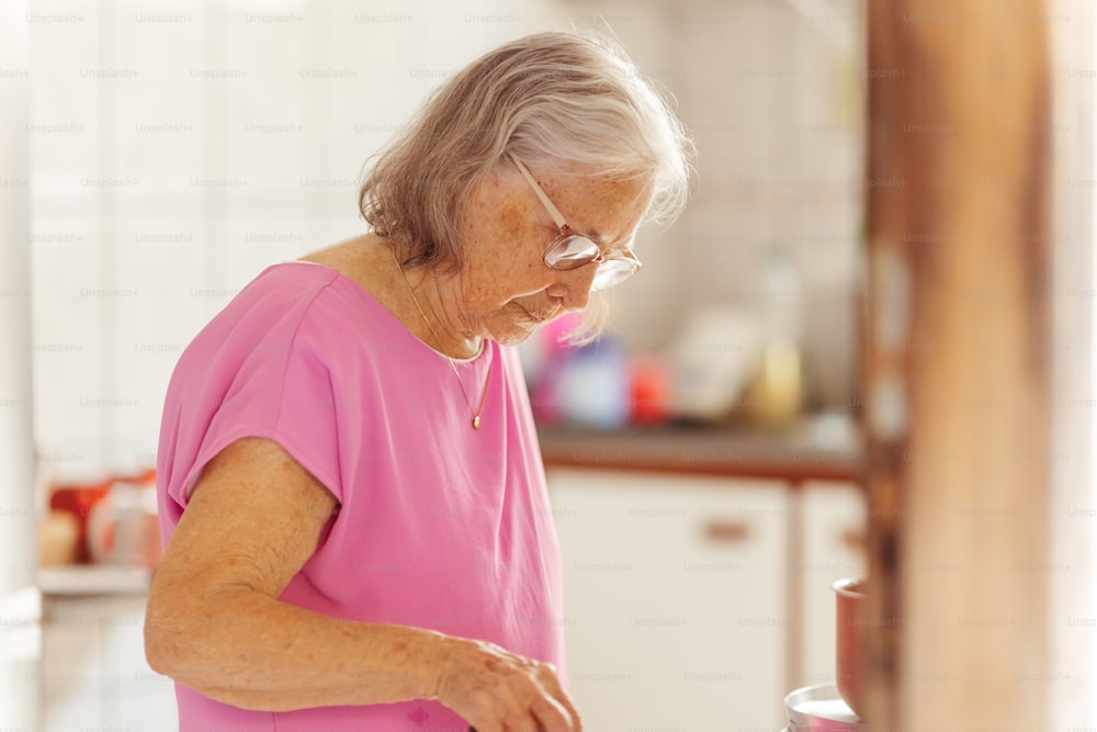 a woman in a pink shirt preparing food in a kitchen