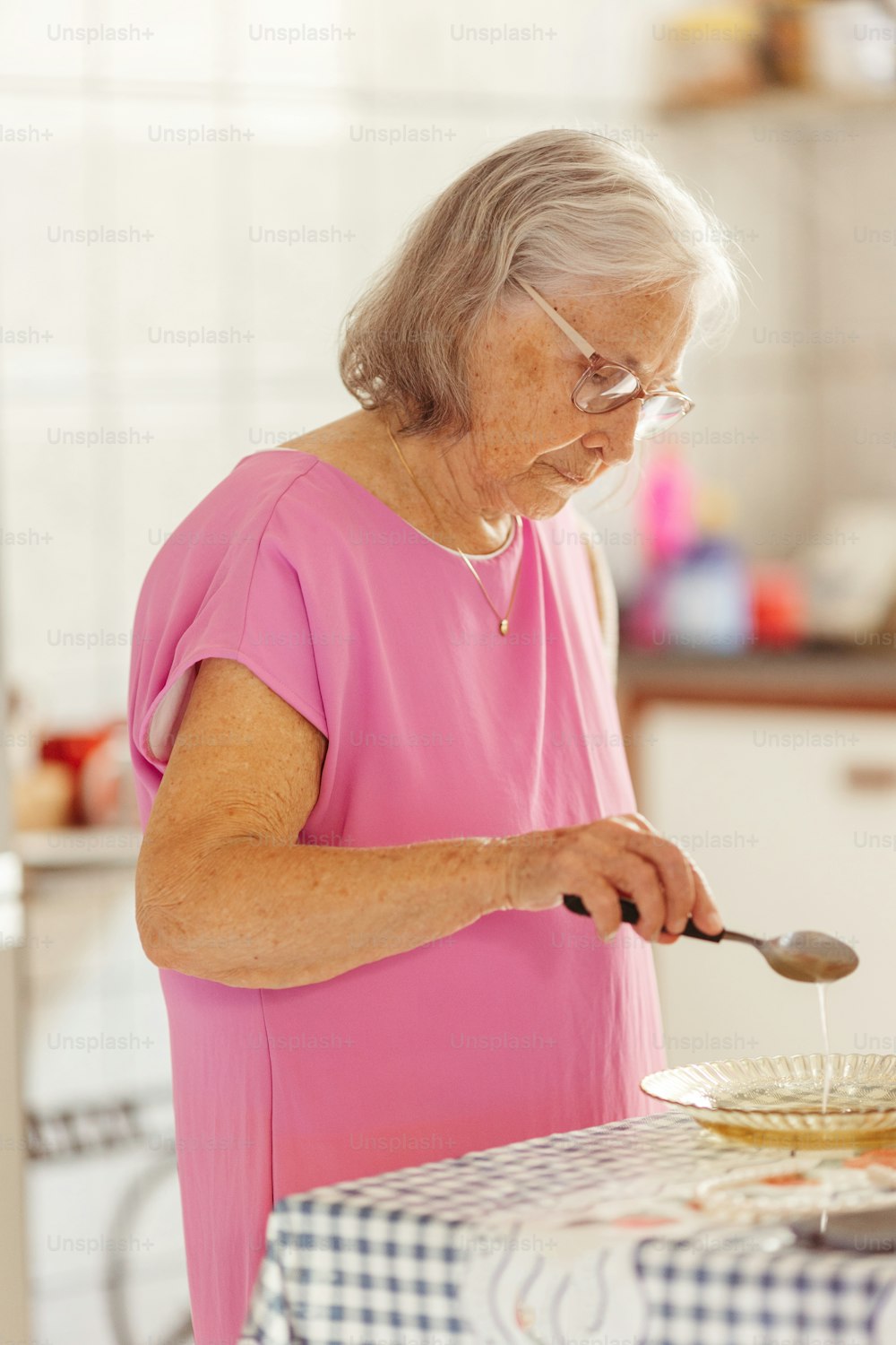 Eine Frau im rosa Hemd bereitet Essen zu