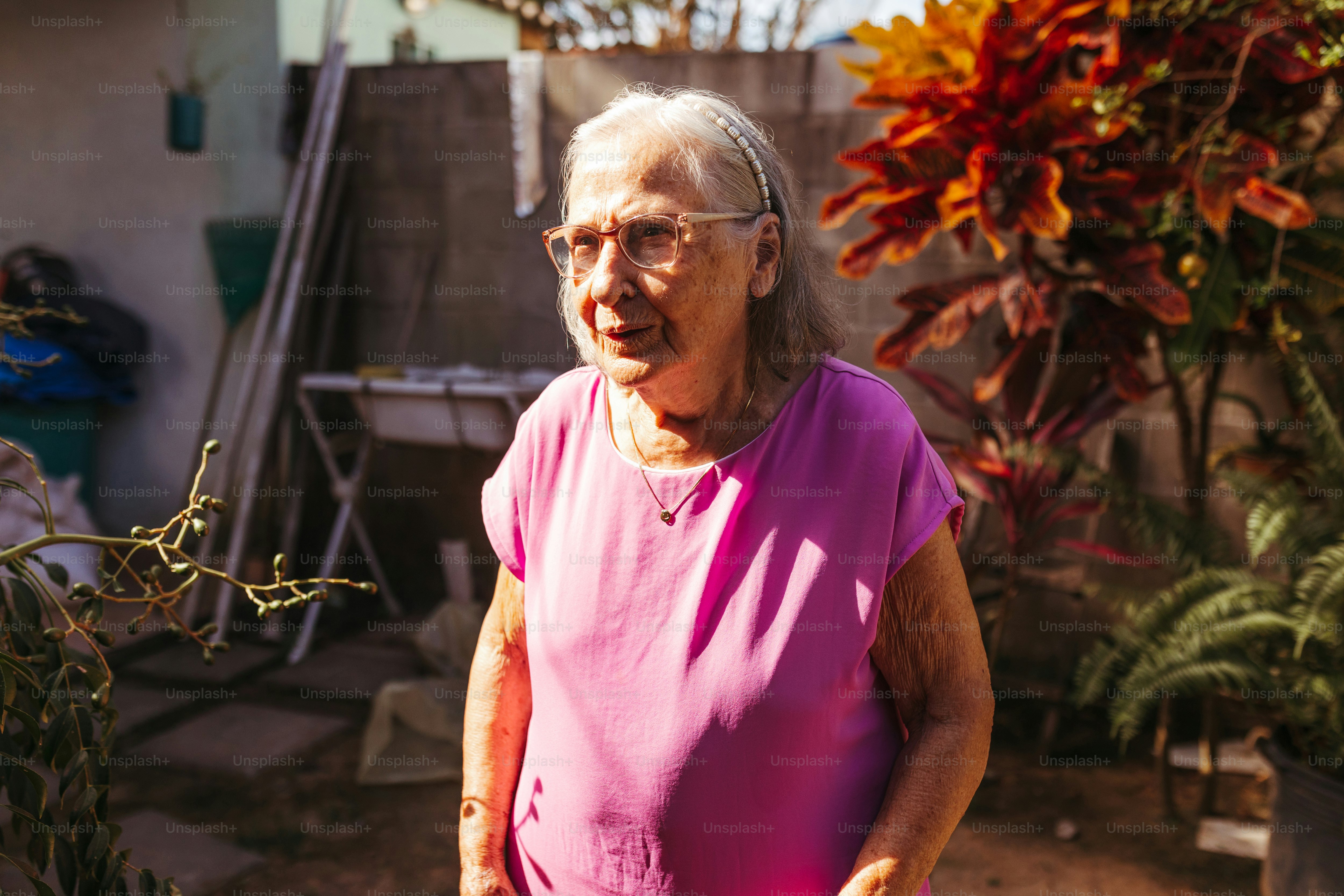 a woman in a pink shirt standing in a garden