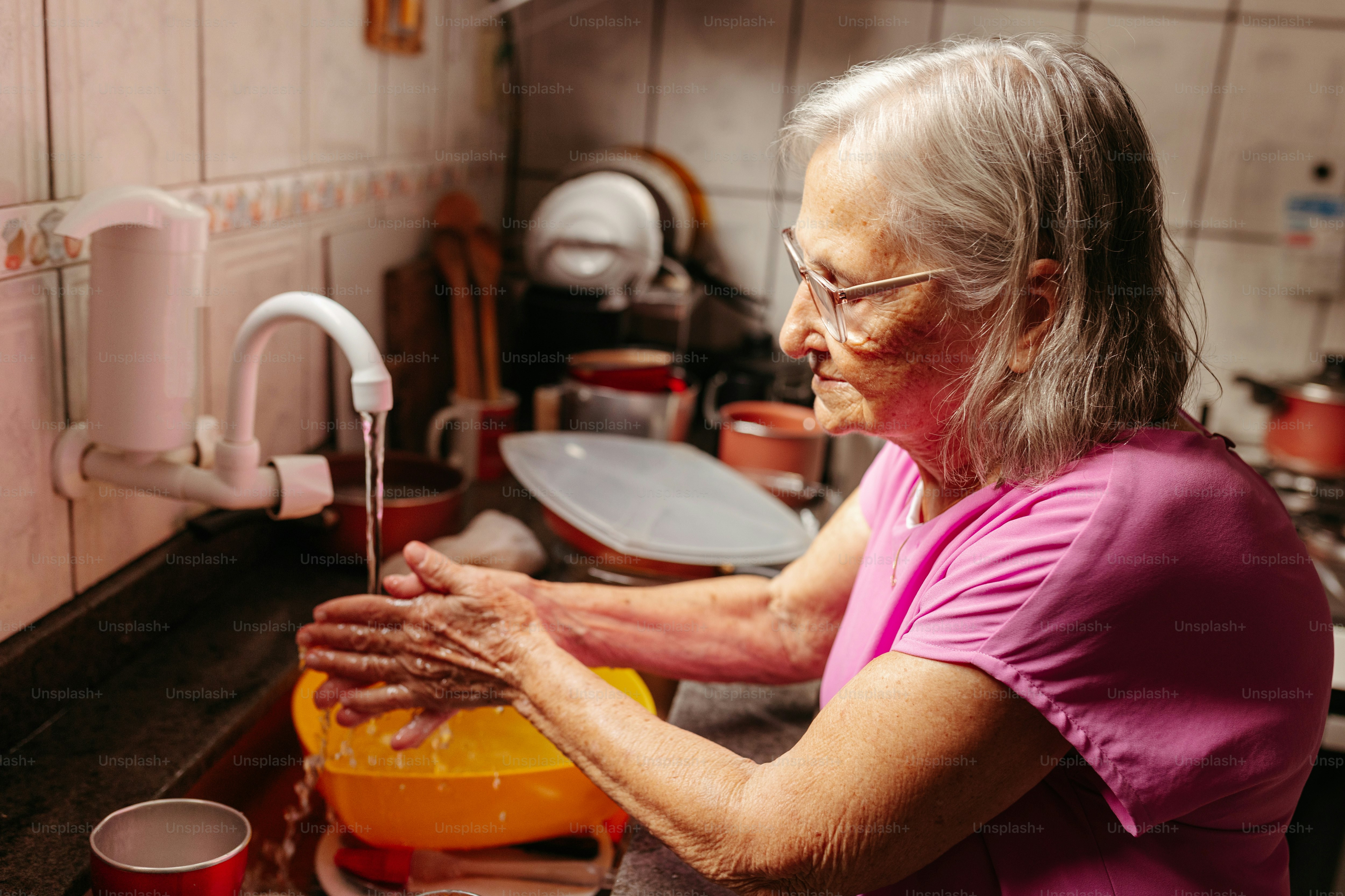 a woman washing her hands in a sink
