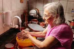 a woman washing her hands in a sink