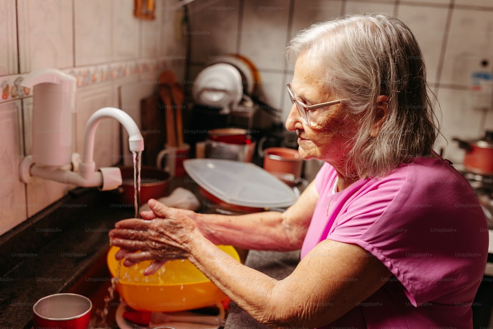 uma mulher lavando as mãos em uma pia