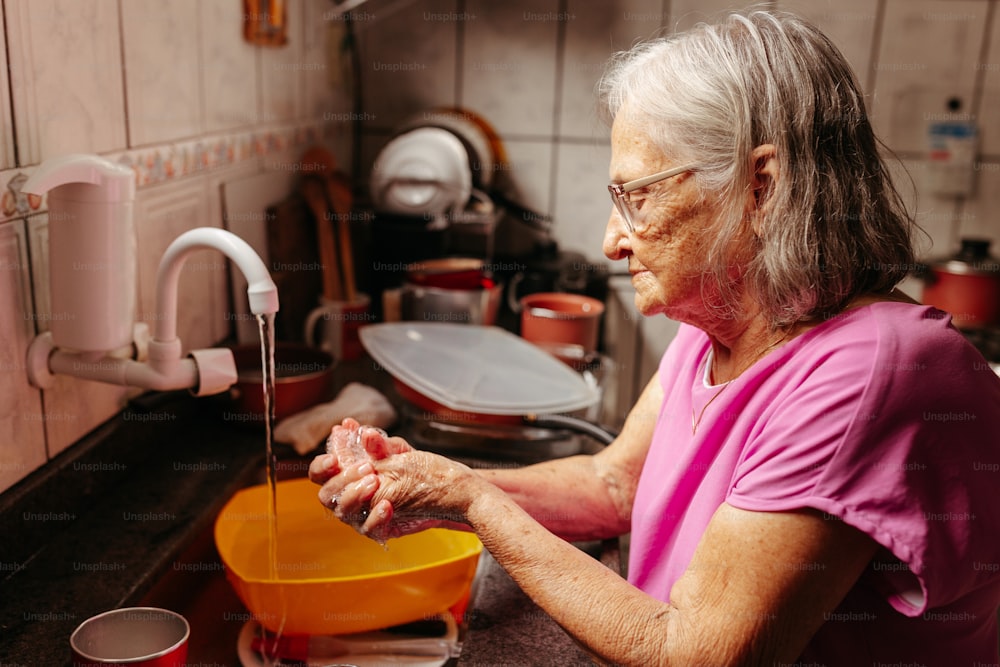 Une femme se lave les mains dans un évier