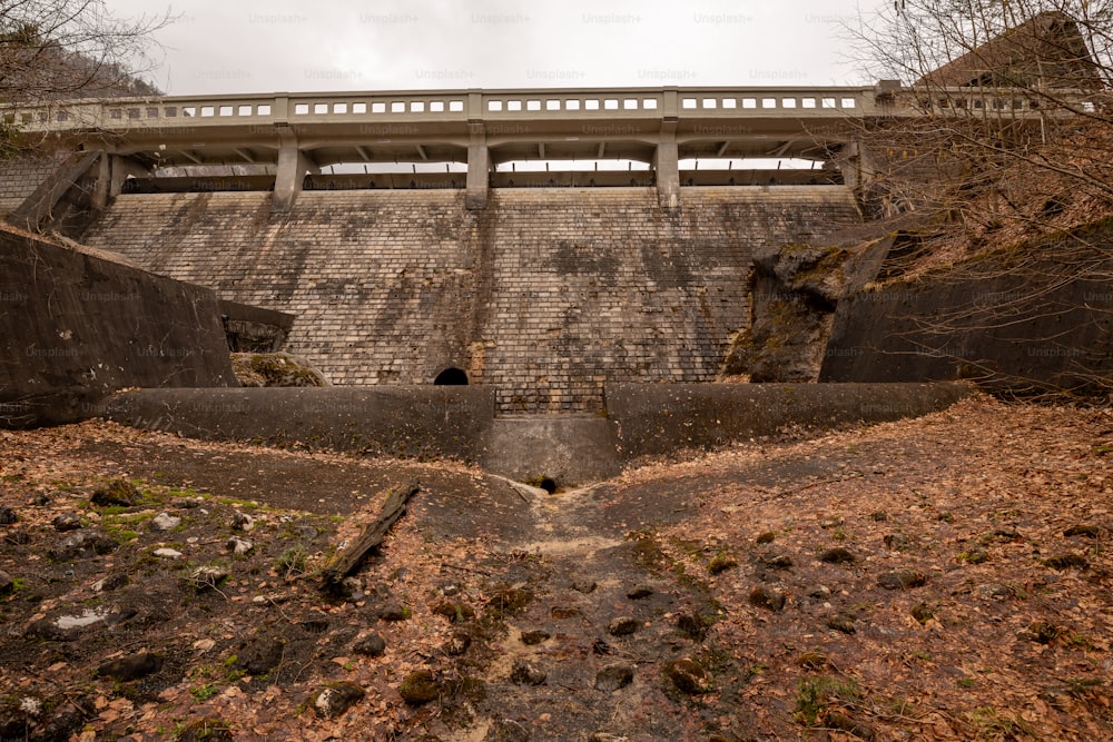 a large brick wall with a bridge above it