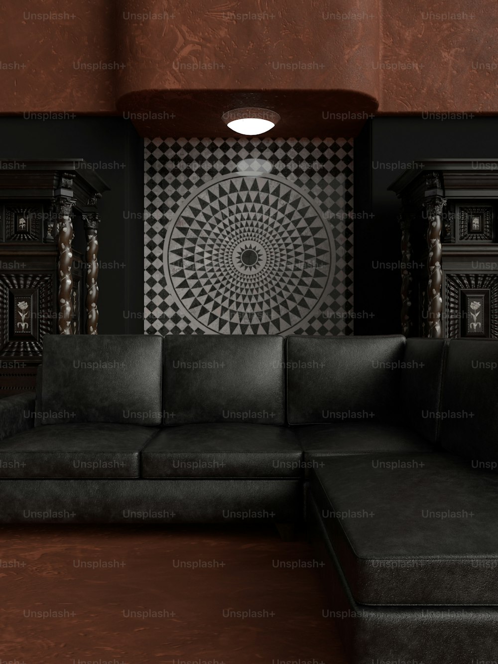um sofá preto sentado em uma sala de estar sob uma luz de teto
