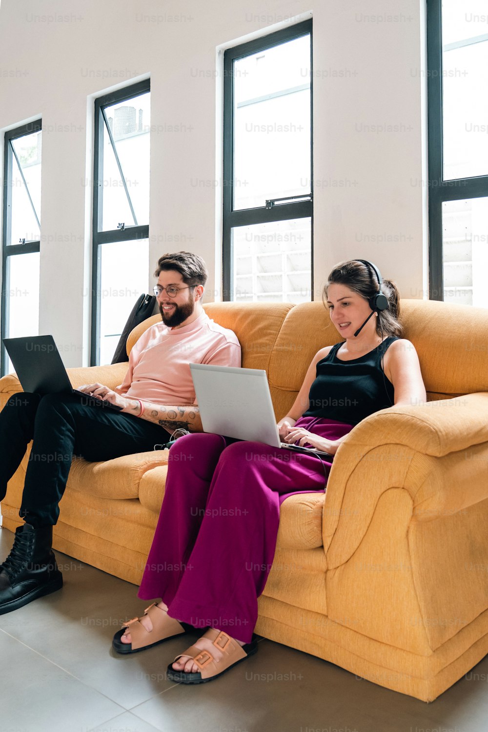 Un hombre y una mujer sentados en un sofá con una computadora portátil