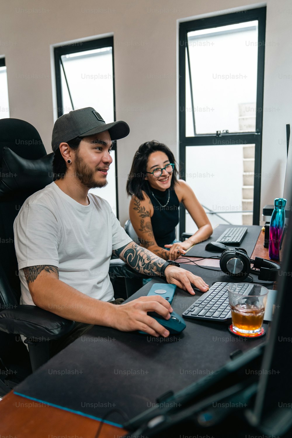 um homem e uma mulher sentados em uma mesa de computador