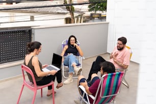 a group of people sitting around each other on chairs