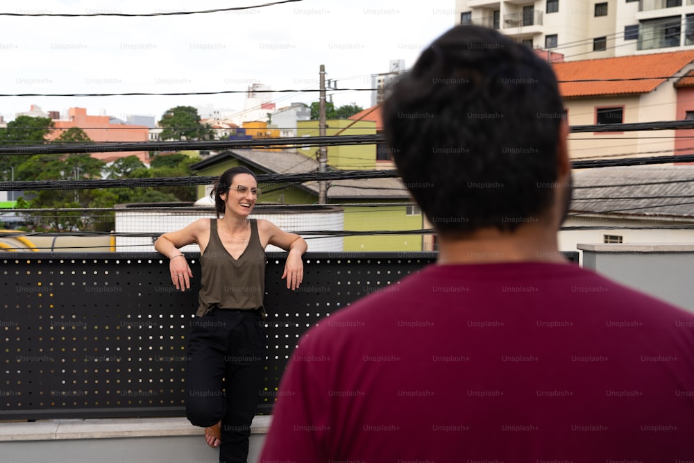 Une femme debout à côté d’un homme sur un toit