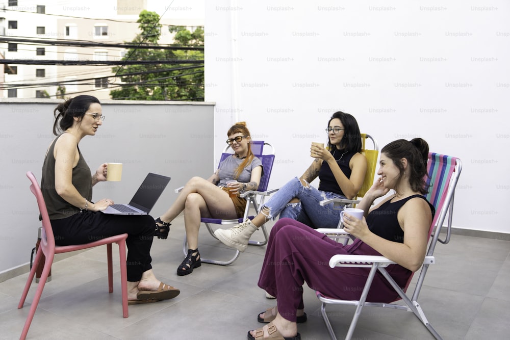 Un groupe de femmes assises autour d’une table avec des ordinateurs portables