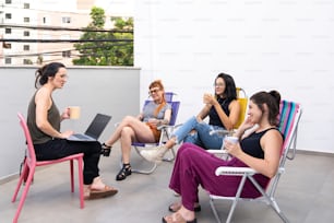 a group of women sitting around a table with laptops