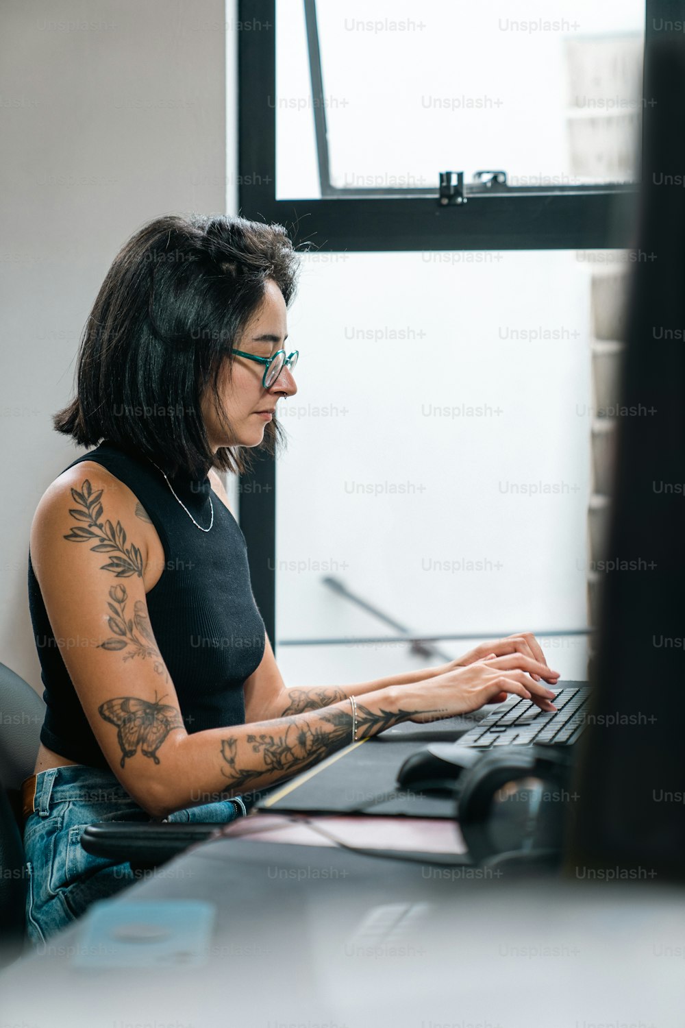 컴퓨터를 사용하여 책상에 앉아 있는 여자