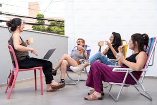 a group of women sitting around each other with laptops