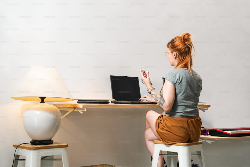 노트북 컴퓨터를 사용��하여 책상에 앉아 있는 여자