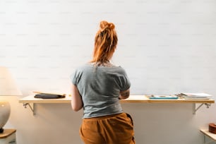 a woman standing in front of a desk with a lamp