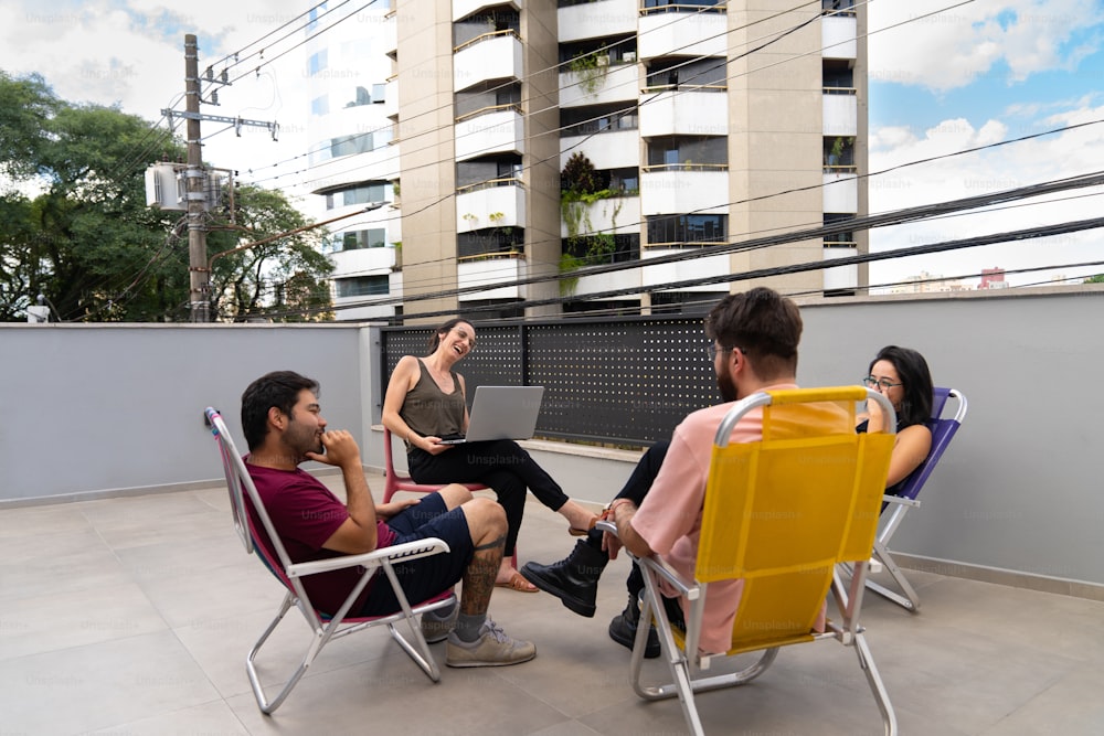 Un grupo de personas sentadas en sillas de jardín en un techo