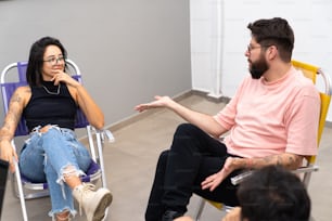 uma mulher sentada em uma cadeira conversando com um homem