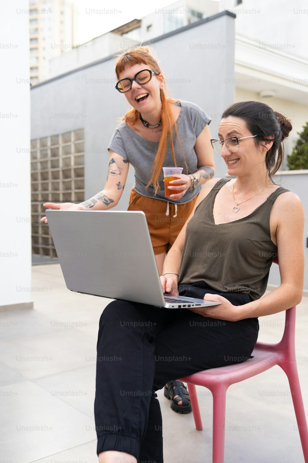 a woman sitting on a chair with a laptop