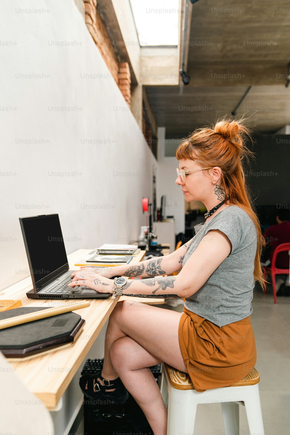 노트북 컴퓨터를 사용하여 책상에 앉아 있는 여자