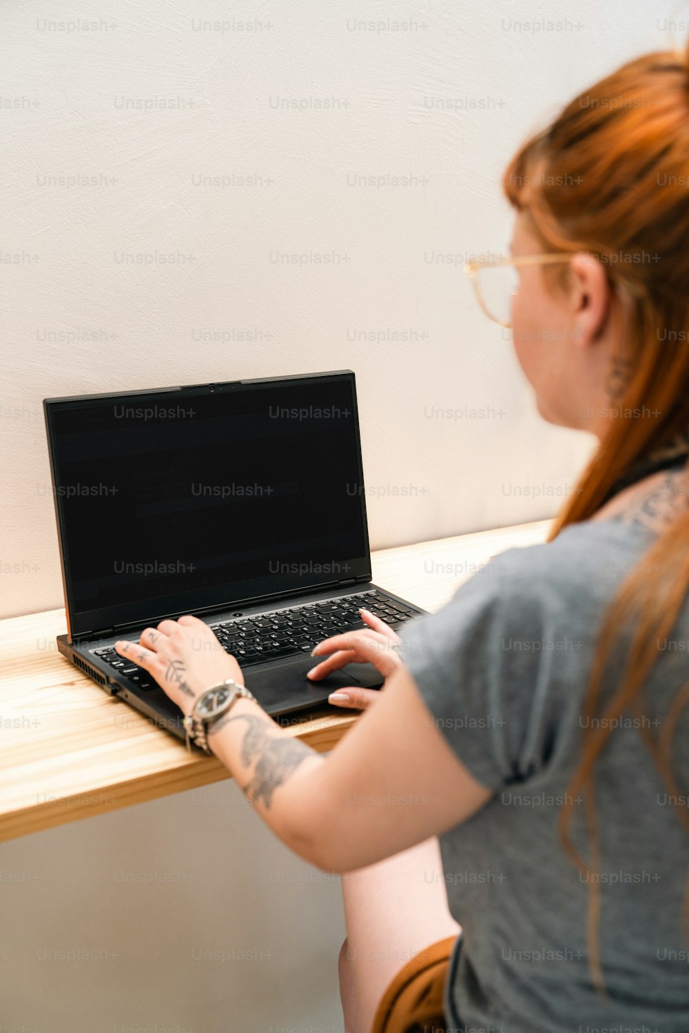 노트북 컴퓨터를 사용하여 테이블에 앉아 있는 여자