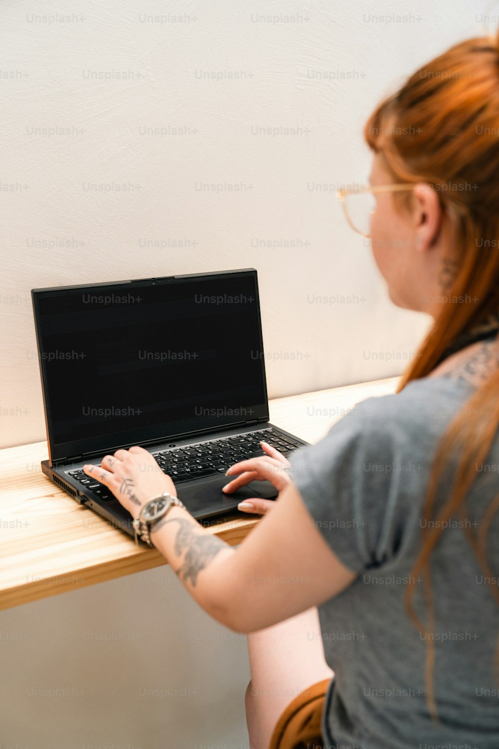 a woman sitting at a table using a laptop computer